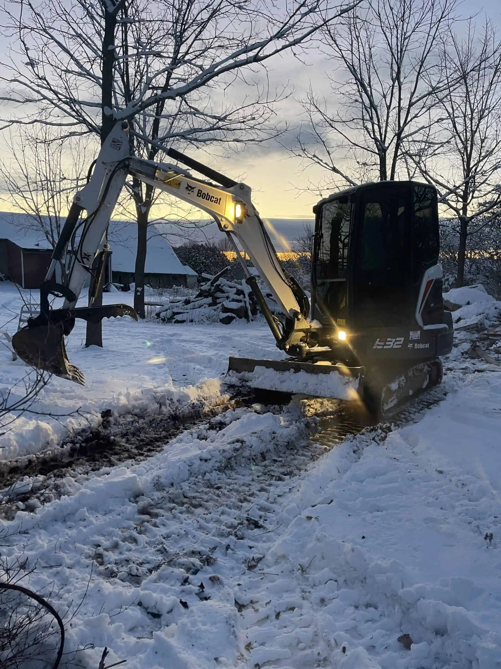a Bobcat excavation machine preparing to dig through the snow